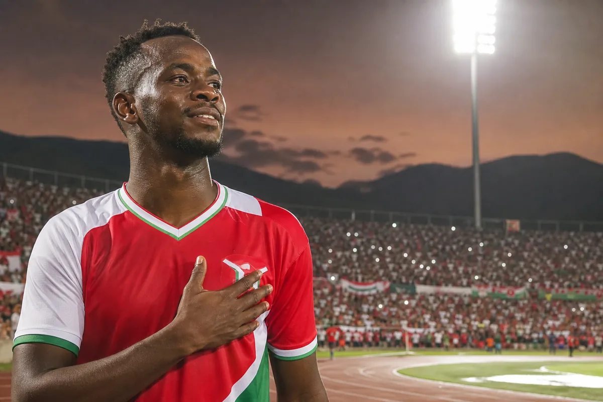 A fictional Burundian national-team striker inspired by Saido Berahino standing proudly before a packed Bujumbura stadium