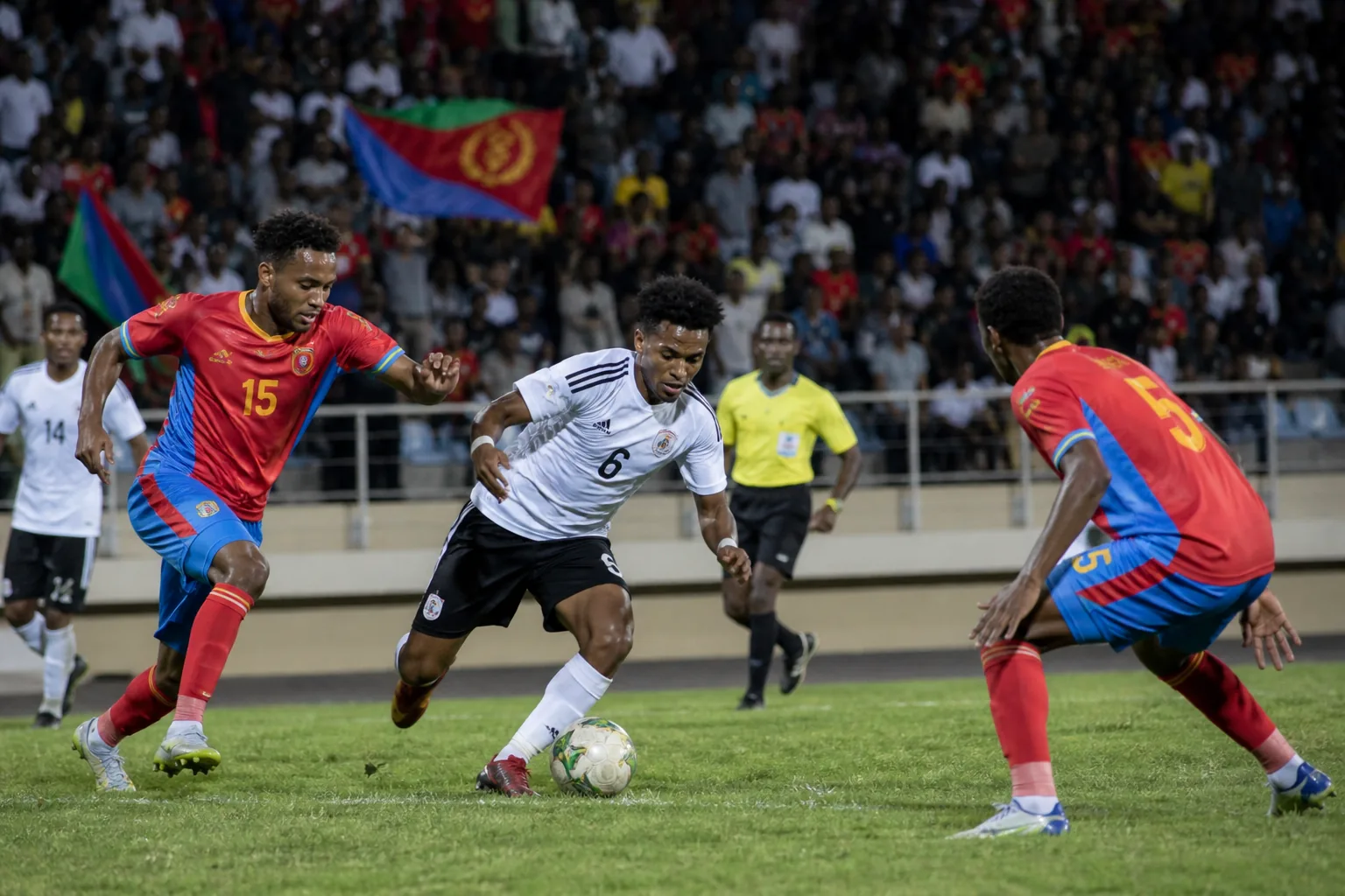 Eritrea players competing in a tense African qualifying match under stadium lights