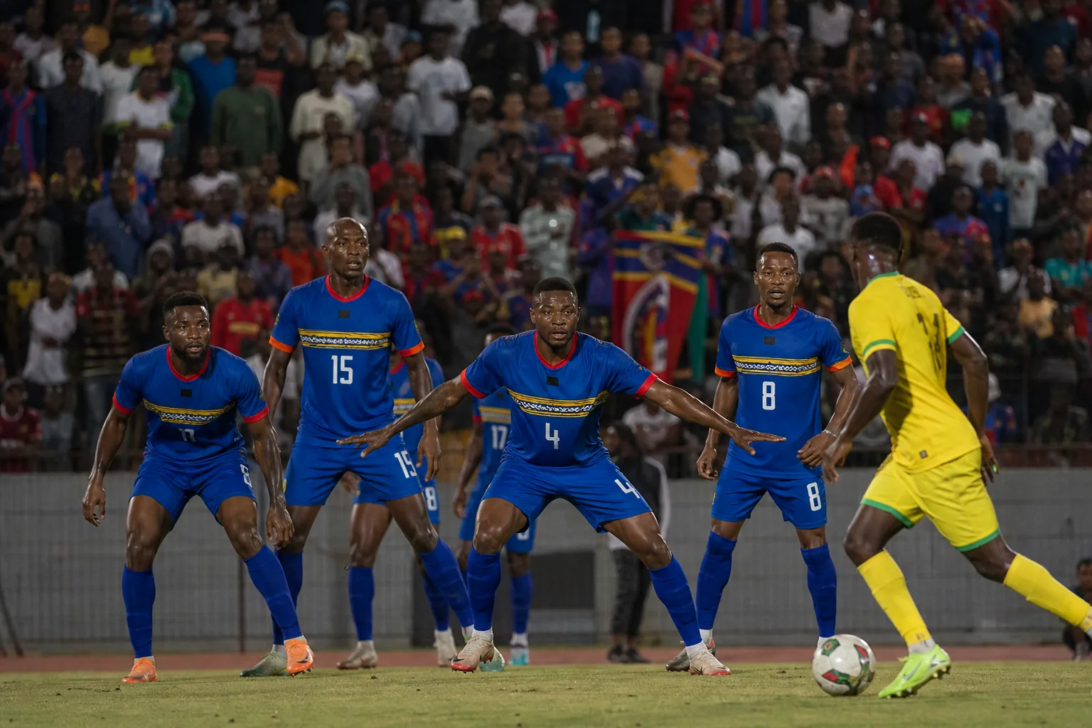 Eswatini national team competing in a tense AFCON qualifying match under stadium lights