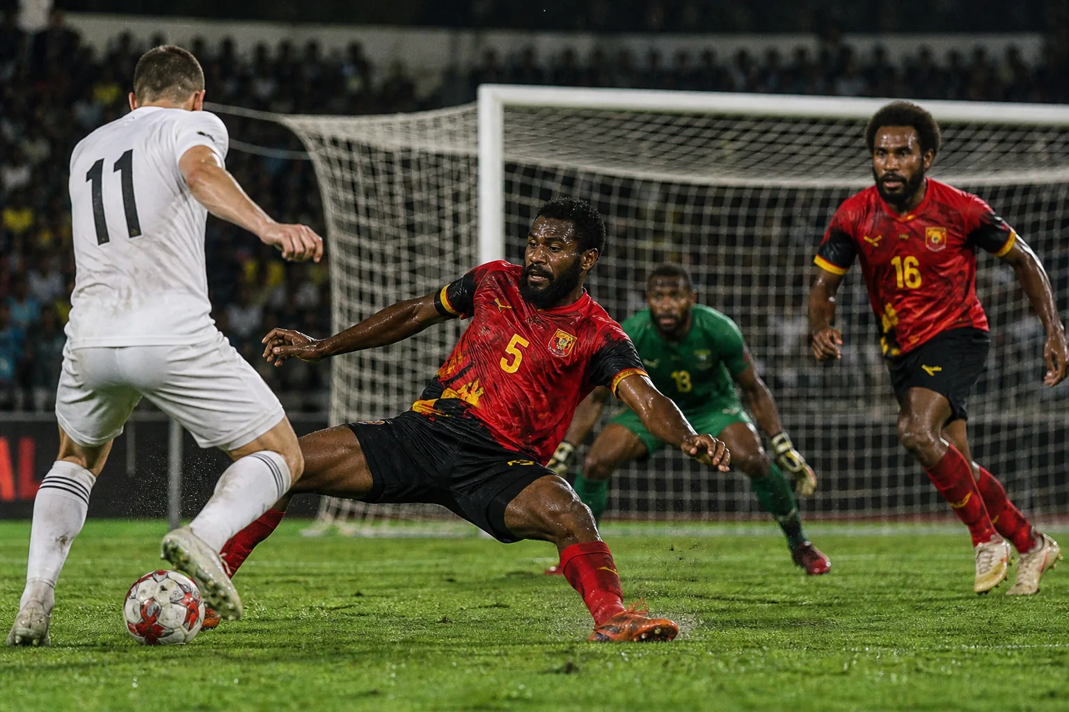 Papua New Guinea Kapuls preparing together for an OFC Nations Cup match in red-and-black kits