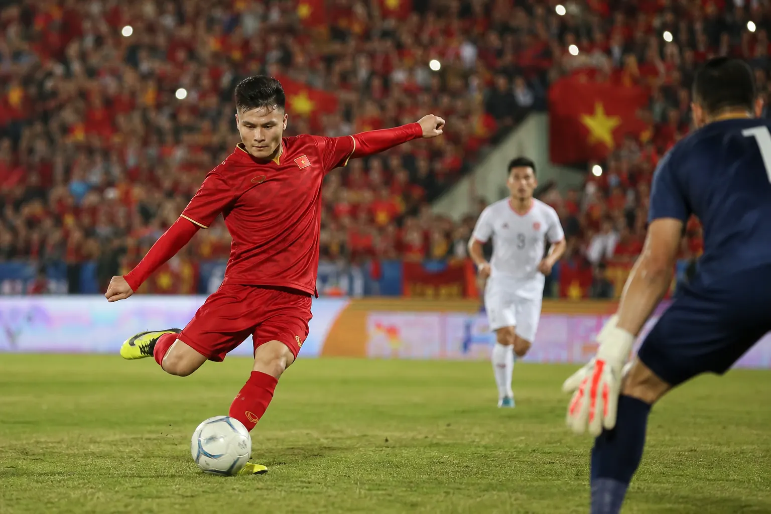 A fictional Vietnamese national-team star attacking midfielder curling a shot toward goal