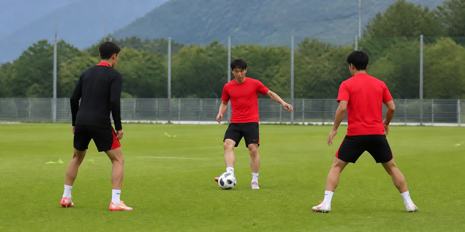 Conceptual illustration of Lee Kang-in and two fictional South Korean teammates practising passes
